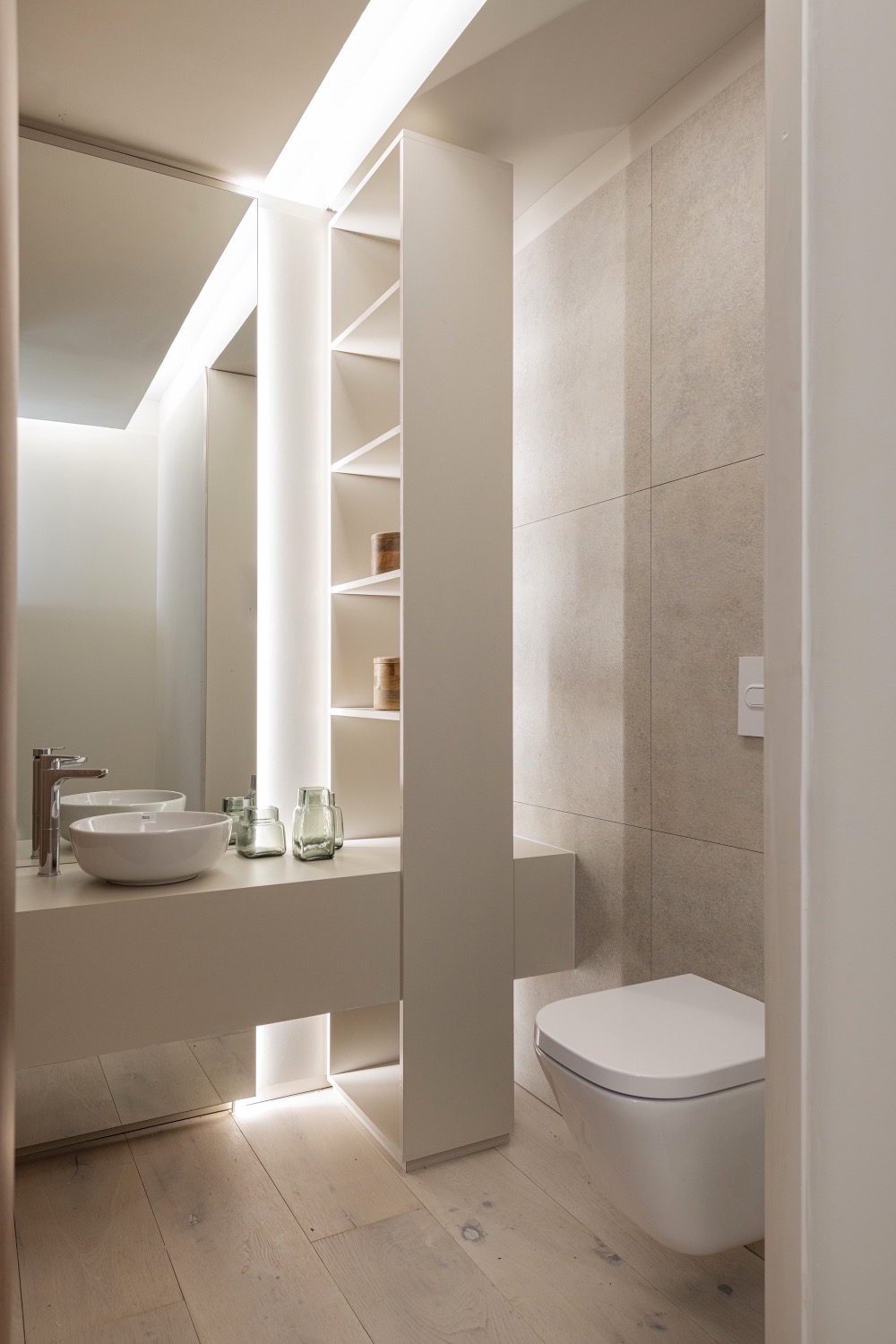 Toilette con doble bacha, estantería blanca y revestimiento de piedra