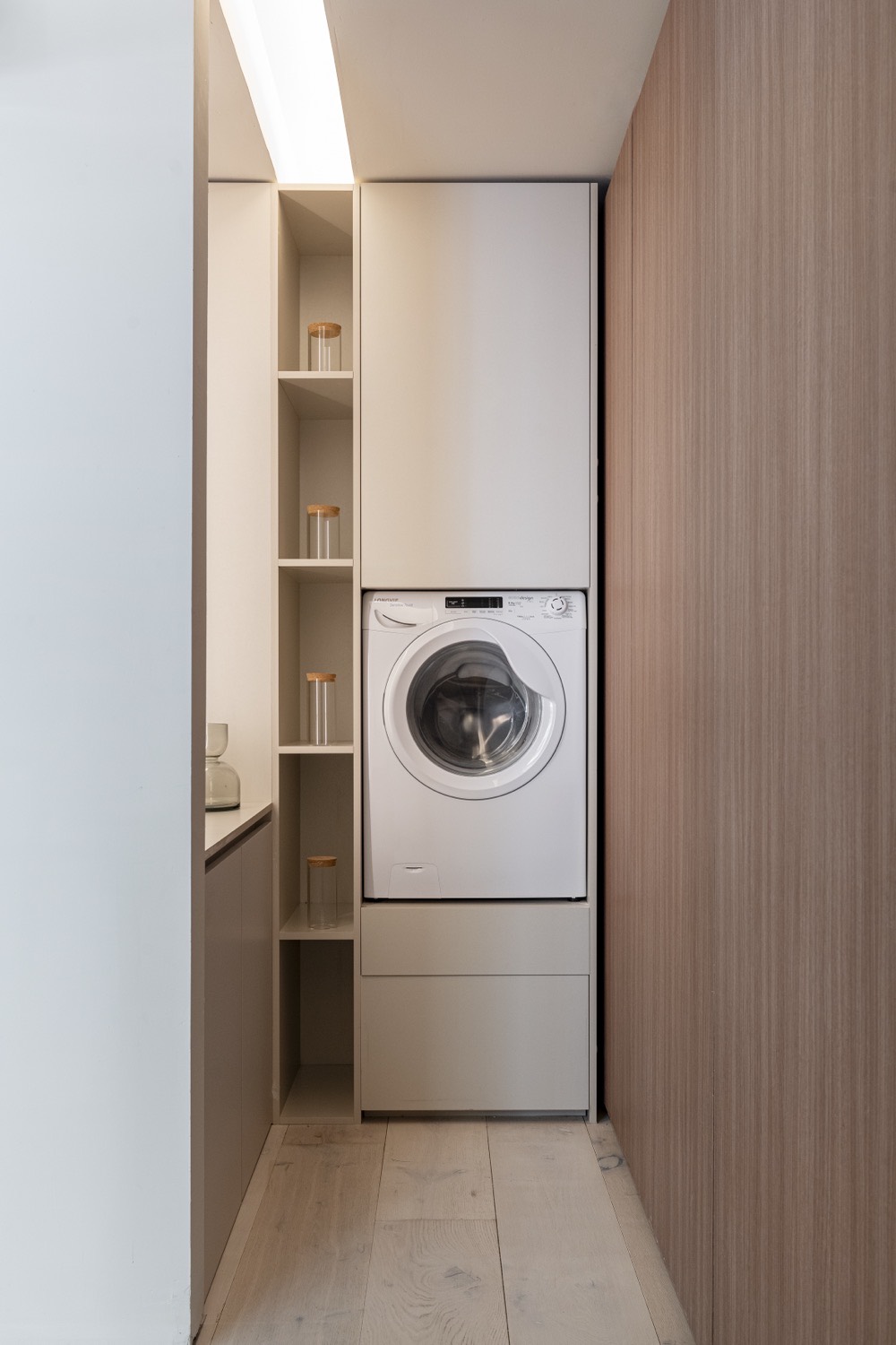Sector de servicios integrado al mueble, con lavarropas y estantería de guardado