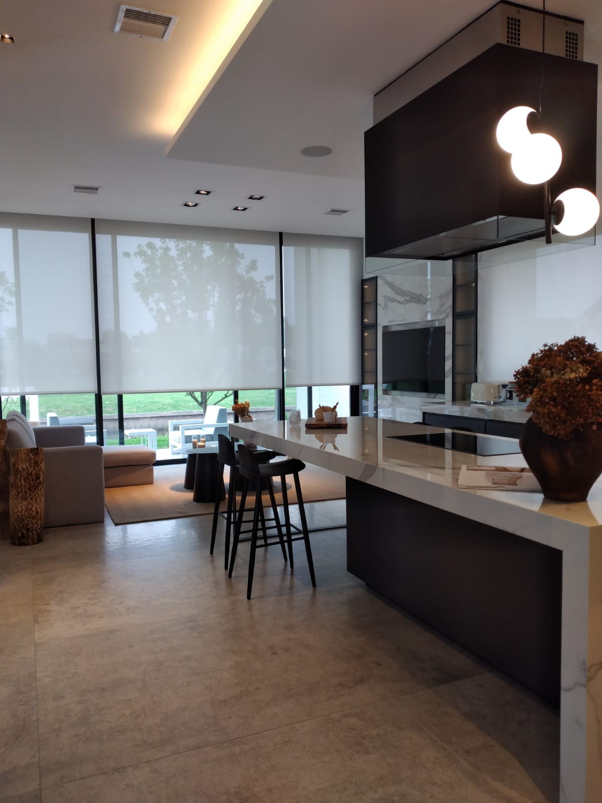 Sector de TV integrado al mueble de la cocina, con la misma materialidad y el estar en continuidad